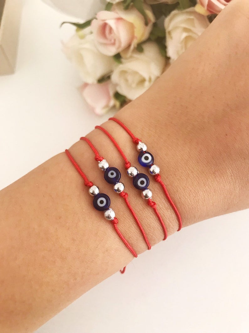 Handmade Evil Eye Bead Bracelet featuring a blue evil eye bead on an adjustable red macramé string.