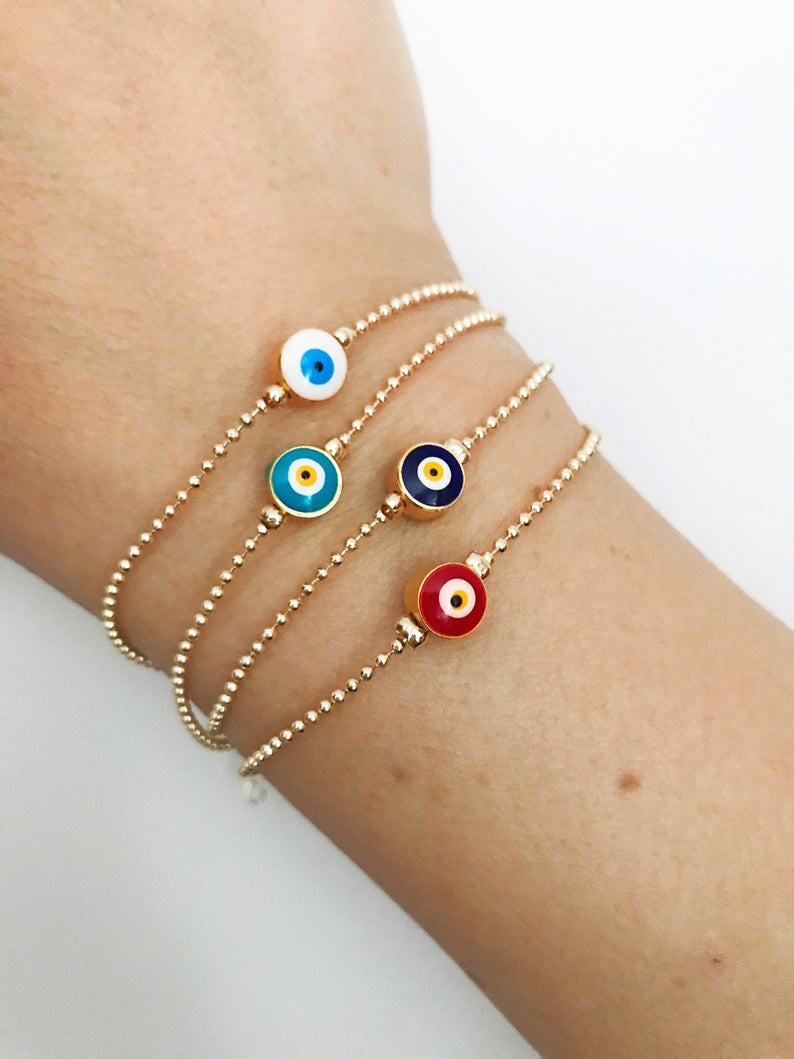 A stylish Evil Eye Bead Bracelet featuring a blue evil eye bead on a delicate gold chain, showcasing its minimalist design and adjustable length.