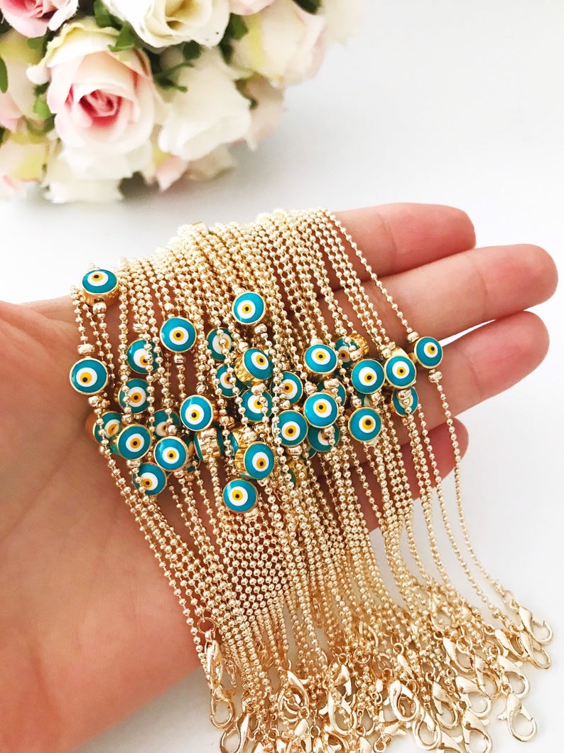 A stylish Evil Eye Bead Bracelet featuring a blue evil eye bead on a delicate gold chain, showcasing its minimalist design and adjustable length.