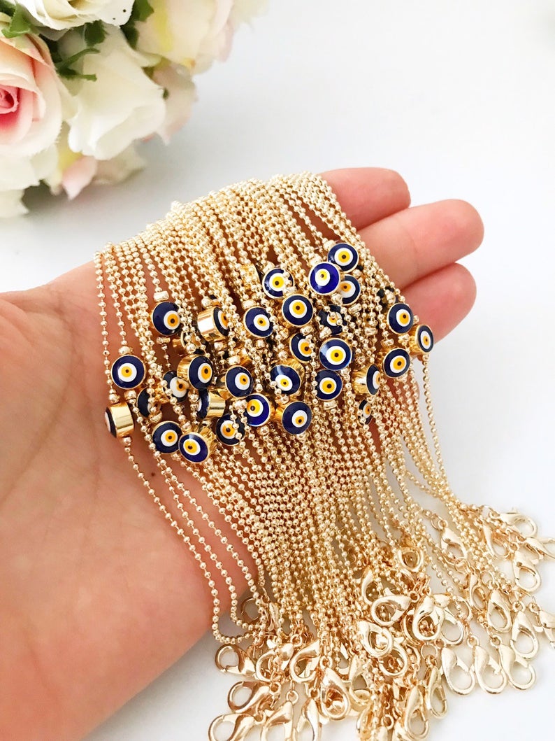 A stylish Evil Eye Bead Bracelet featuring a blue evil eye bead on a delicate gold chain, showcasing its minimalist design and adjustable length.