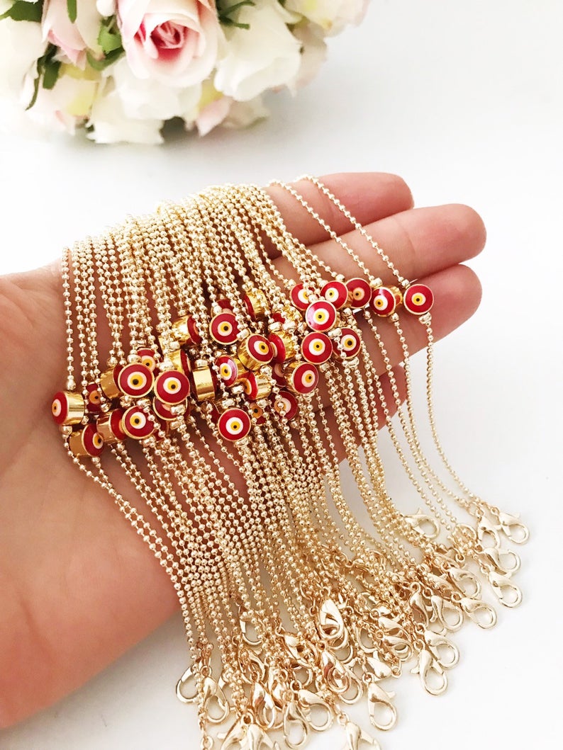 A stylish Evil Eye Bead Bracelet featuring a blue evil eye bead on a delicate gold chain, showcasing its minimalist design and adjustable length.