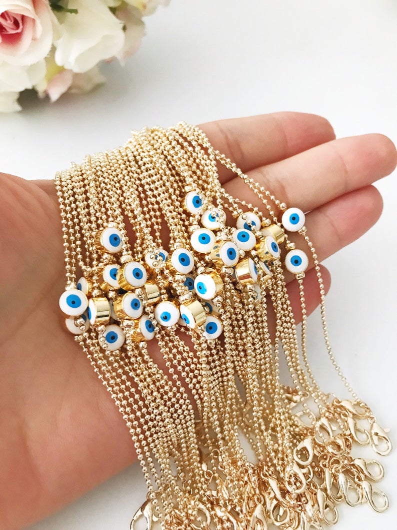 A stylish Evil Eye Bead Bracelet featuring a blue evil eye bead on a delicate gold chain, showcasing its minimalist design and adjustable length.