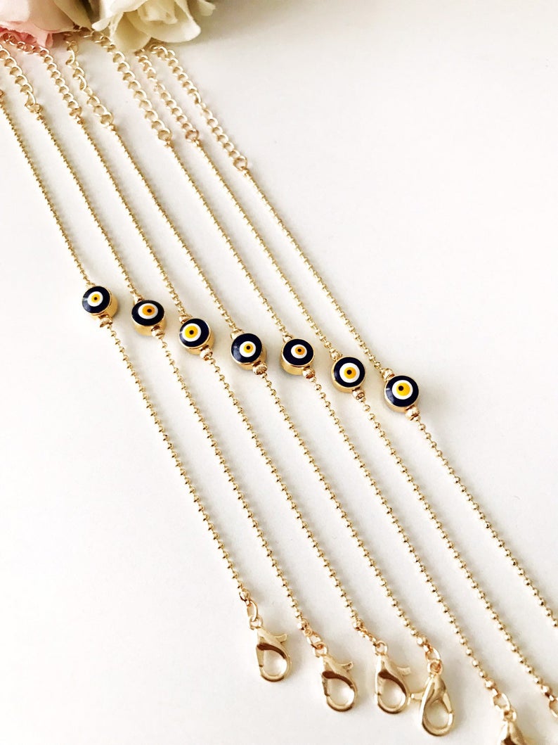 A stylish Evil Eye Bead Bracelet featuring a blue evil eye bead on a delicate gold chain, showcasing its minimalist design and adjustable length.