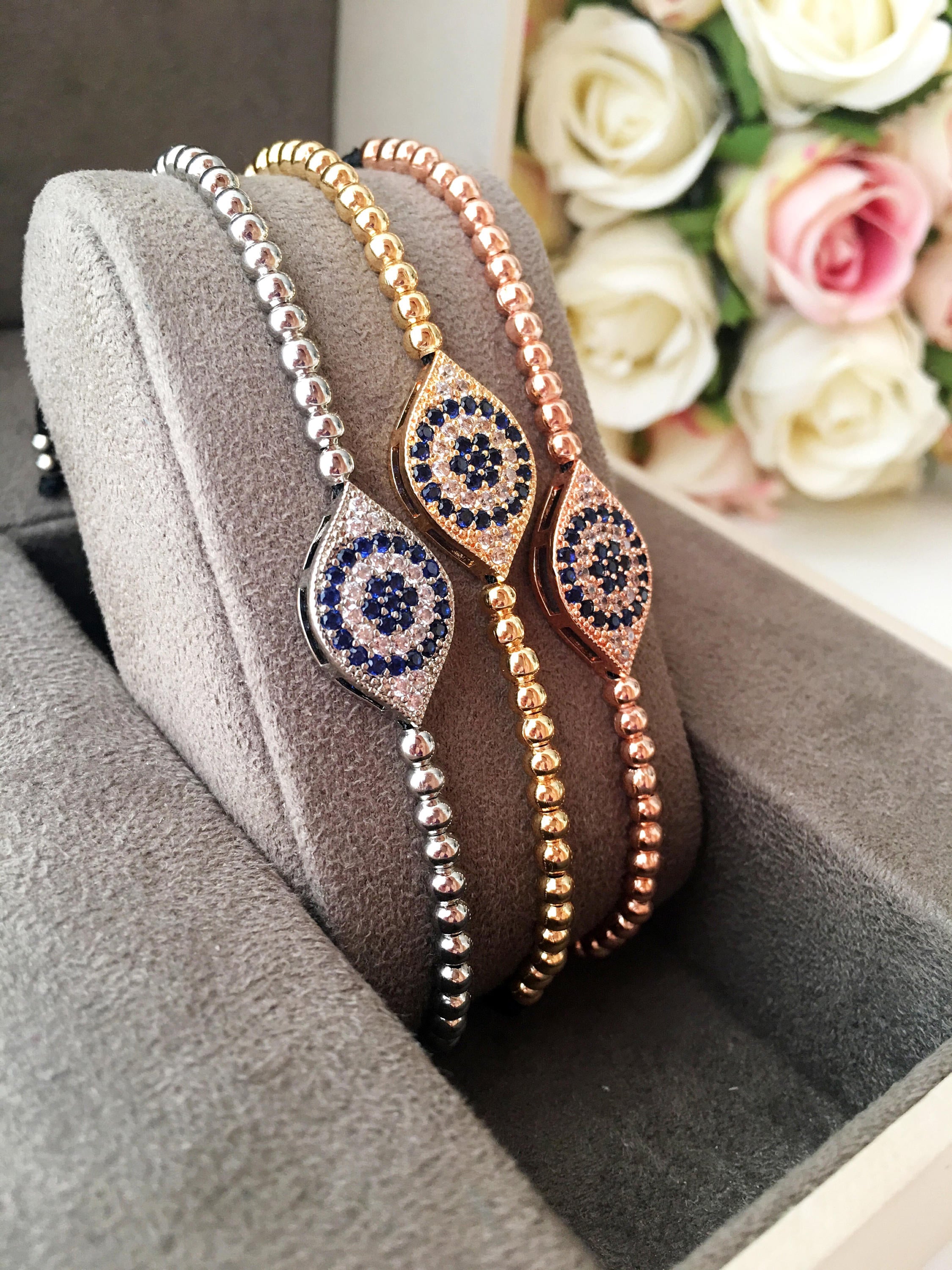 Evil Eye Beaded Bracelet in rose gold and silver, featuring adjustable design and zirconia accents, perfect for protection and style.