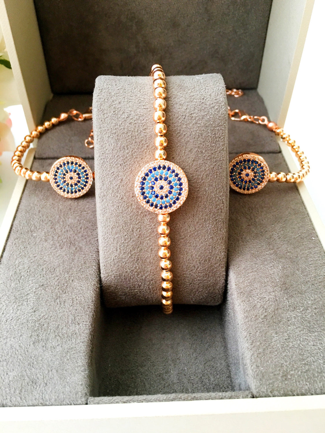 A stunning Evil Eye Beaded Bracelet featuring a zirconia evil eye charm, adjustable design, and available in rose gold and silver finishes.
