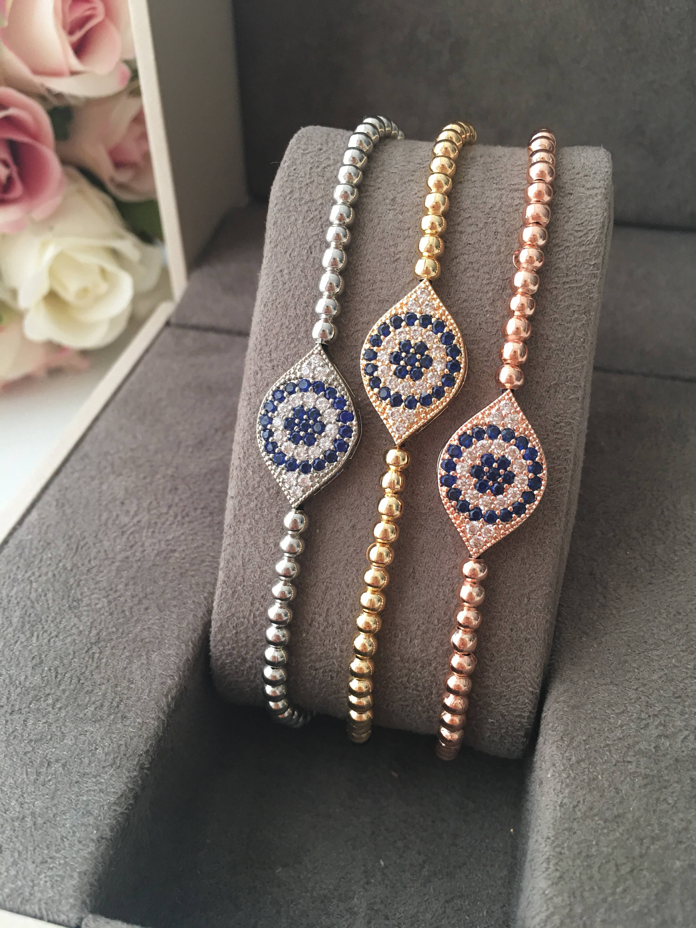 A stunning Evil Eye Beaded Bracelet featuring a zirconia evil eye charm, adjustable design, and available in rose gold and silver finishes.