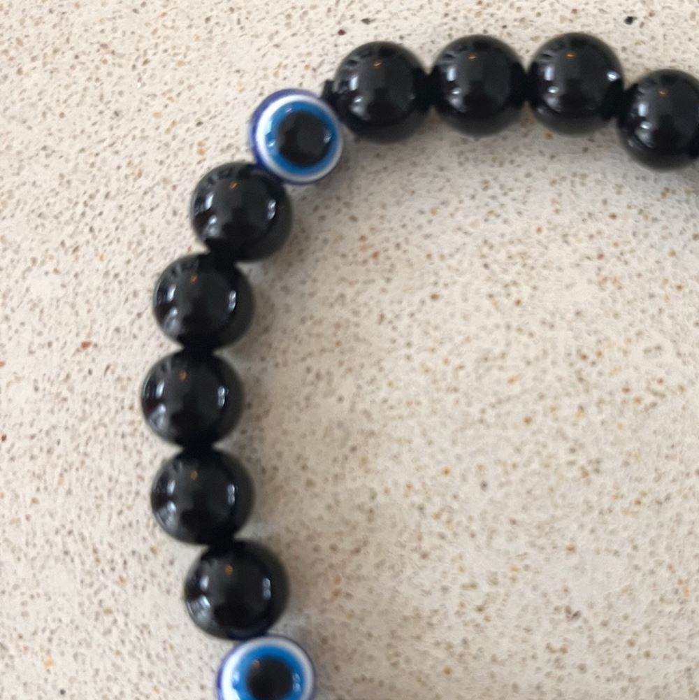 Evil Eye Beaded Stretch Bracelet made of black obsidian, featuring a stylish design with protective symbolism.
