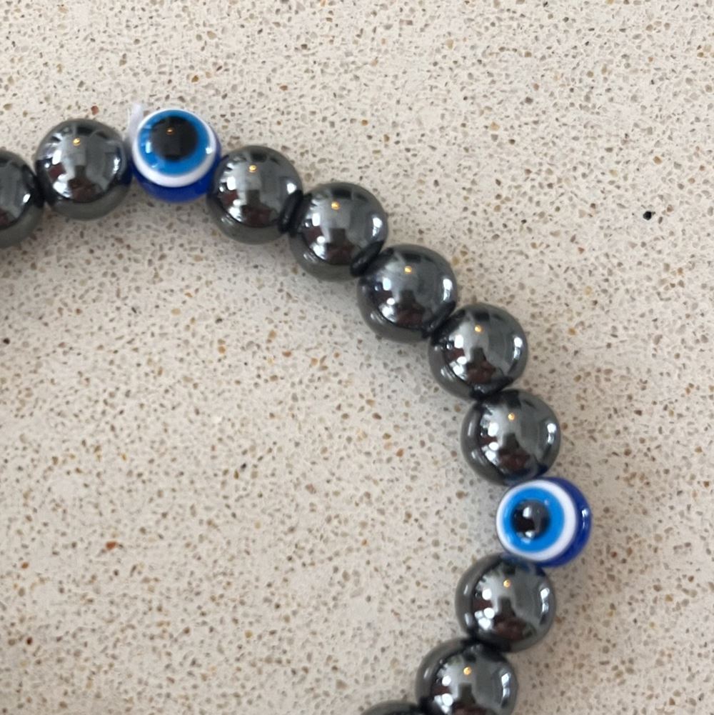 Evil Eye Beaded Stretch Bracelet made of hematite beads, featuring a vibrant design symbolizing protection and good luck.