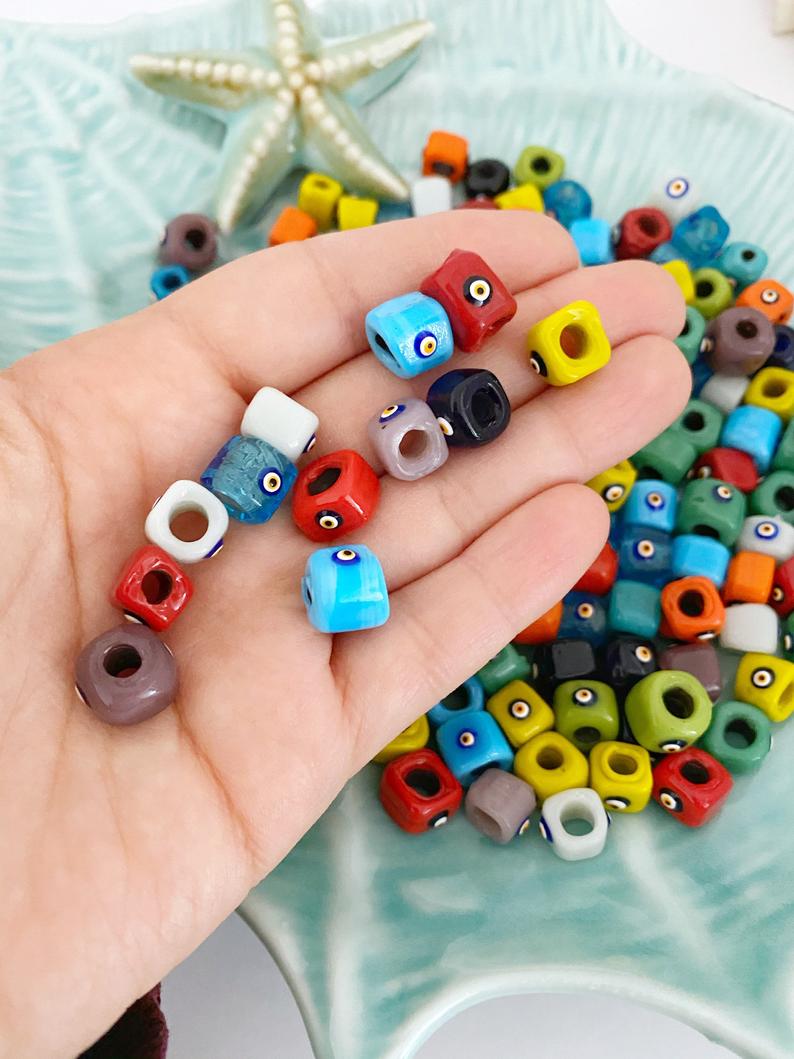 Handmade Murano glass Evil Eye beads in 12mm cube shape, showcasing vibrant colors and intricate designs, perfect for jewelry making.