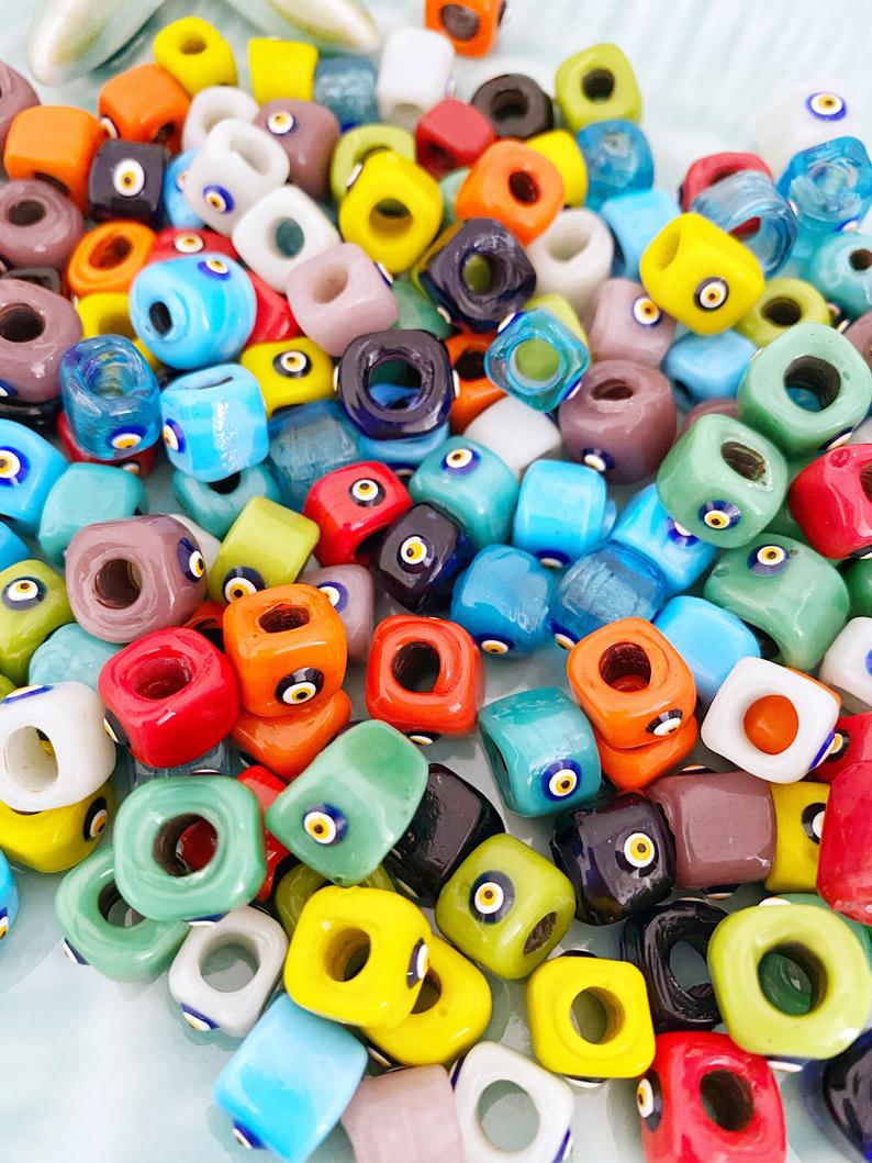Handmade Murano glass Evil Eye beads in 12mm cube shape, showcasing vibrant colors and intricate designs, perfect for jewelry making.