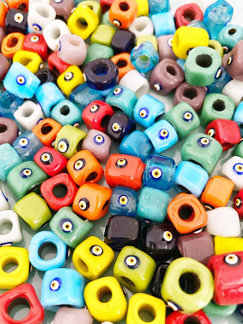 Handmade Murano glass Evil Eye beads in 12mm cube shape, showcasing vibrant colors and intricate designs, perfect for jewelry making.