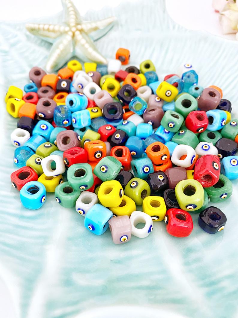 Handmade Murano glass Evil Eye beads in 12mm cube shape, showcasing vibrant colors and intricate designs, perfect for jewelry making.