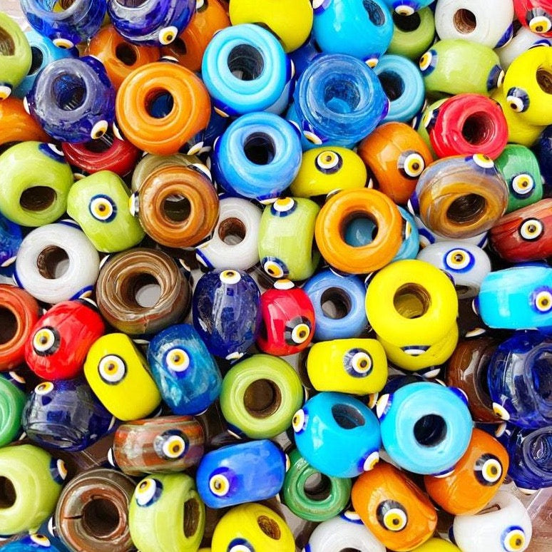 A collection of colorful handmade Murano glass Evil Eye beads, showcasing intricate designs and vibrant colors, perfect for jewelry making.