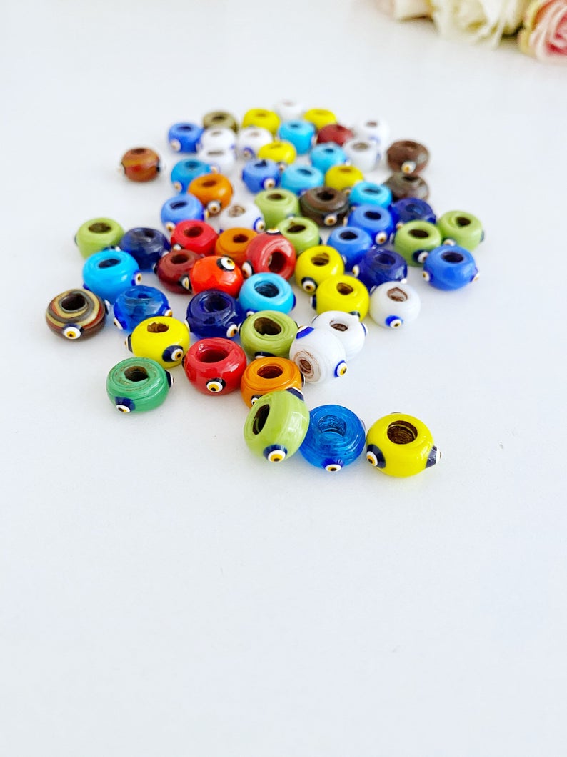 A collection of colorful handmade Murano glass Evil Eye beads, showcasing intricate designs and vibrant colors, perfect for jewelry making.