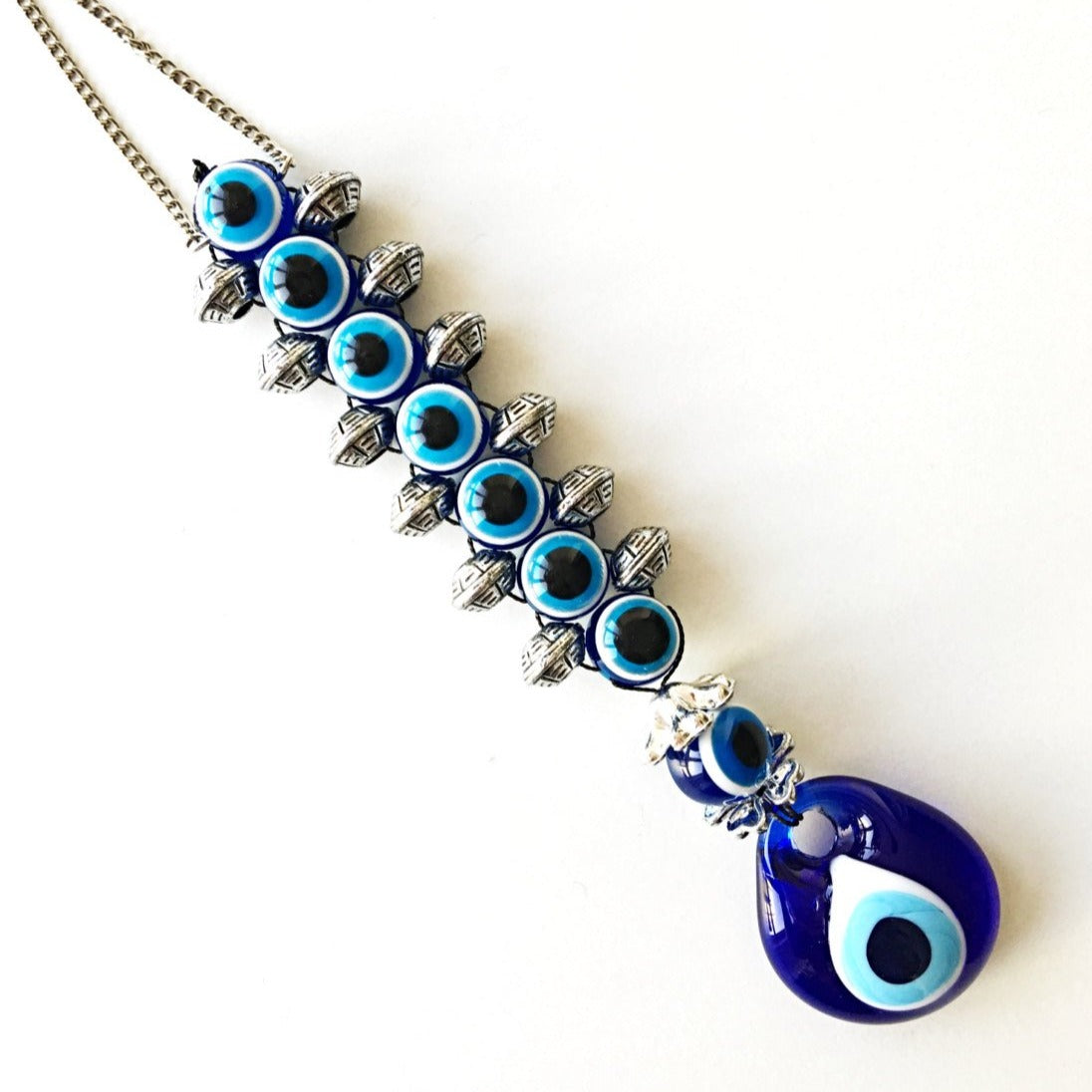 Handmade evil eye wall hanging featuring a large 5cm blue evil eye bead surrounded by smaller glass evil eyes, symbolizing protection and good fortune.