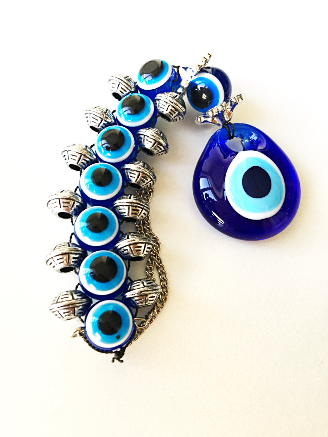 Handmade evil eye wall hanging featuring a large 5cm blue evil eye bead surrounded by smaller glass evil eyes, symbolizing protection and good fortune.