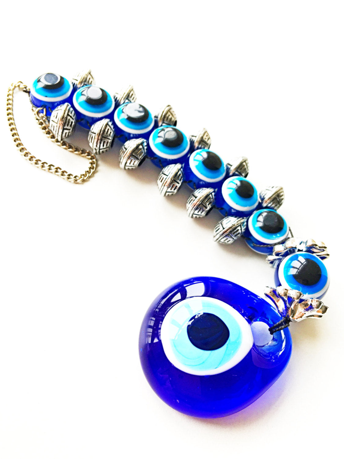Handmade evil eye wall hanging featuring a large 5cm blue evil eye bead surrounded by smaller glass evil eyes, symbolizing protection and good fortune.