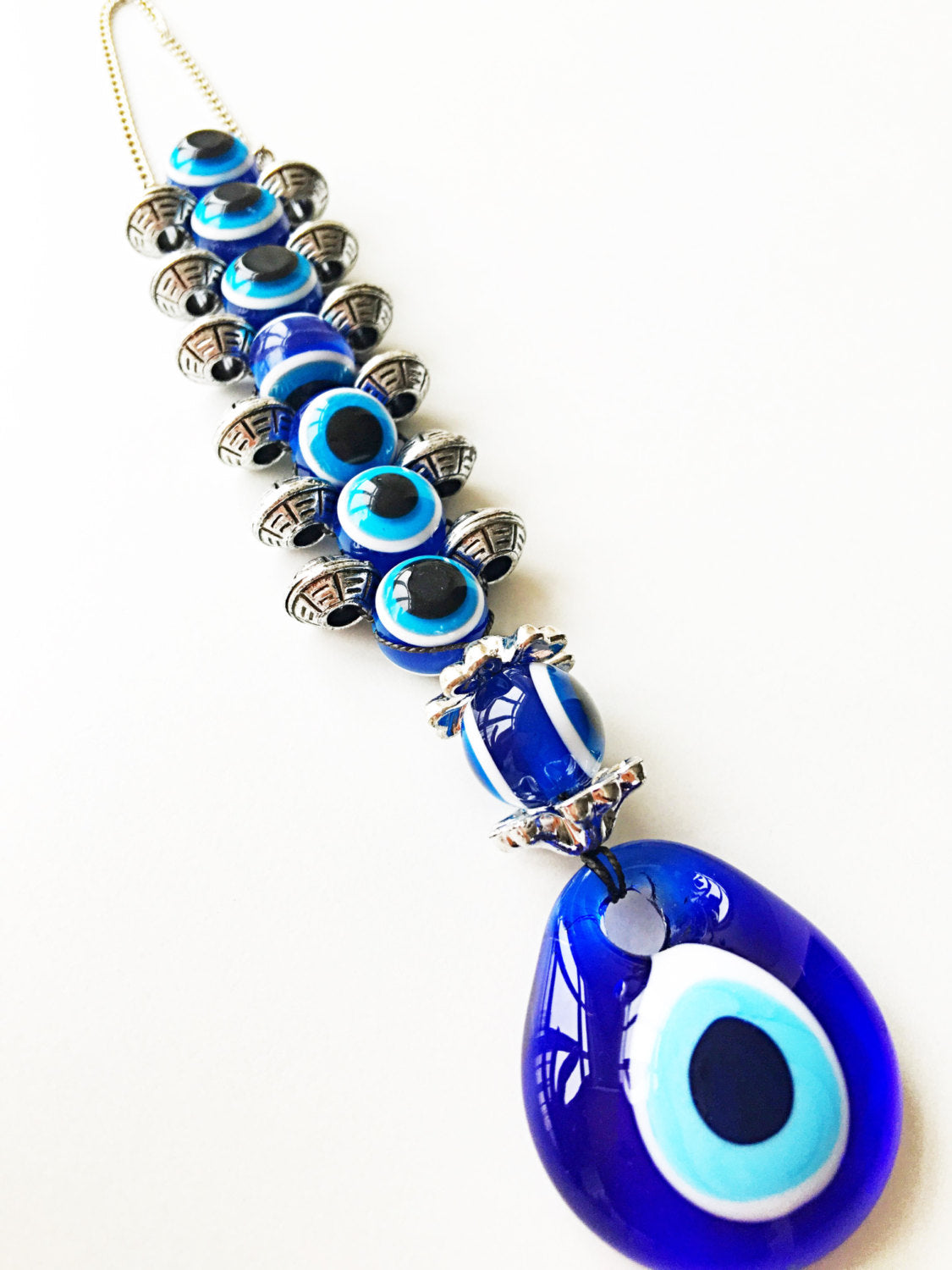 Handmade evil eye wall hanging featuring a large 5cm blue evil eye bead surrounded by smaller glass evil eyes, symbolizing protection and good fortune.