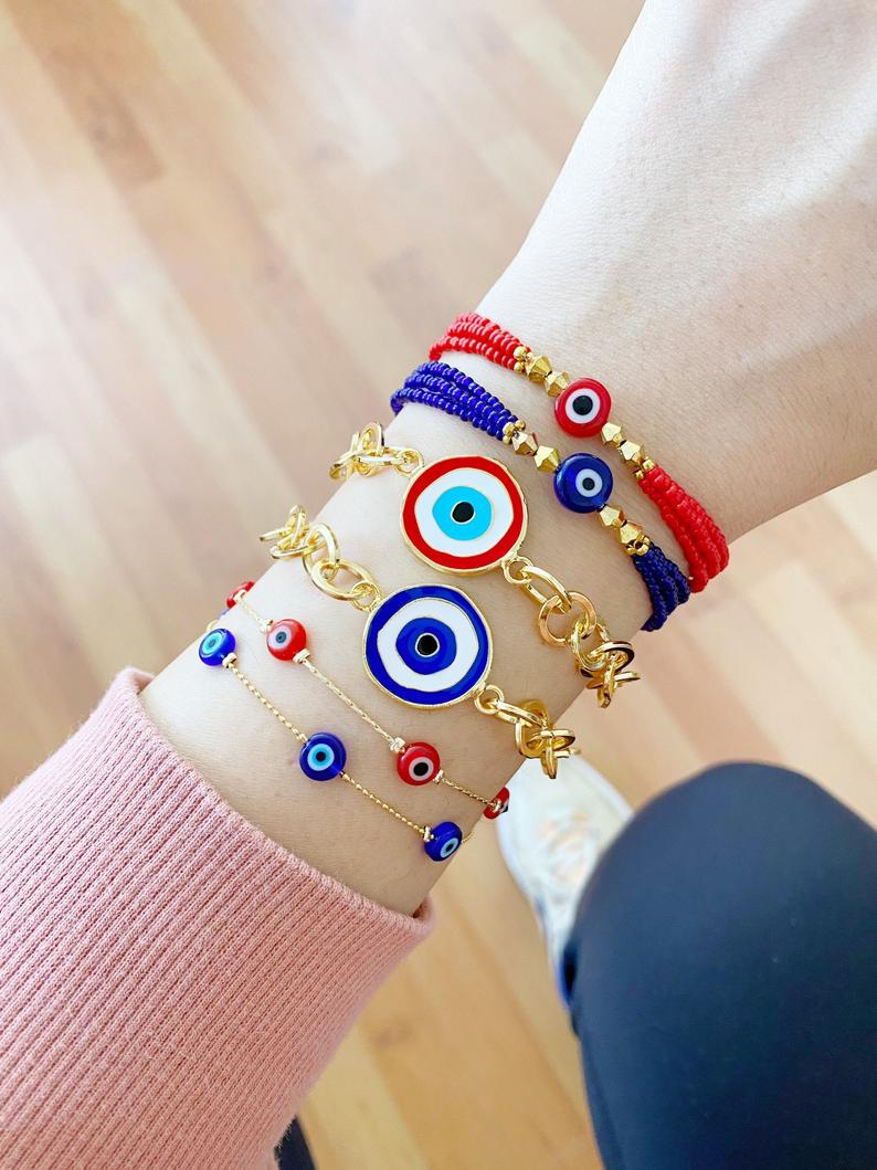 Evil Eye Bracelet featuring blue and red beads on a gold chain, showcasing its handmade craftsmanship and adjustable design.