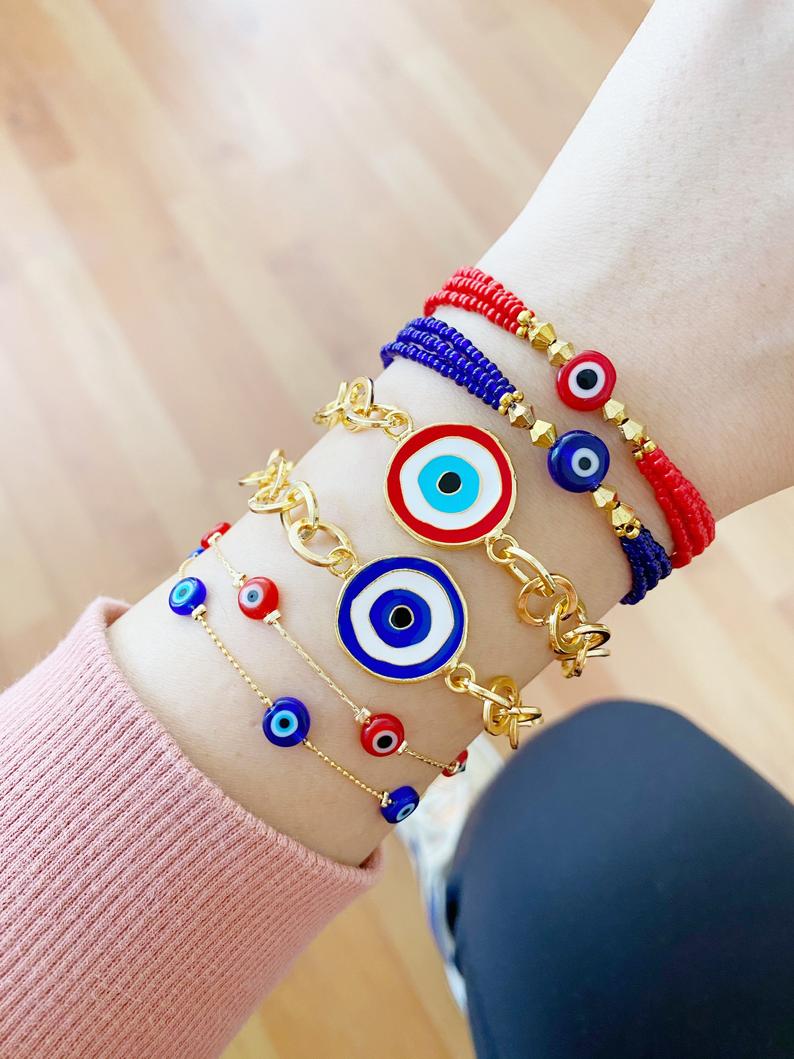 Evil Eye Bracelet featuring blue and red beads on a gold chain, showcasing its handmade craftsmanship and adjustable design.