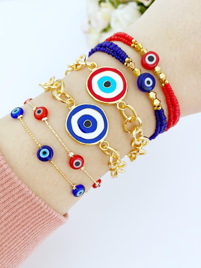 Evil Eye Bracelet featuring blue and red beads on a gold chain, showcasing its handmade craftsmanship and adjustable design.