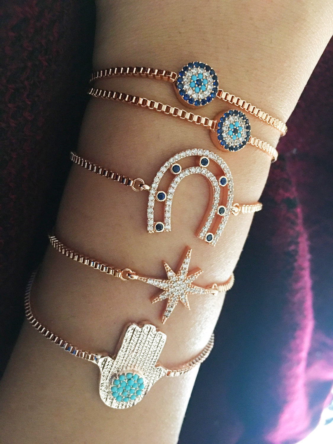 Rose gold adjustable evil eye bracelet, handmade with gold plating, featuring hamsa and horseshoe designs for protection and style.