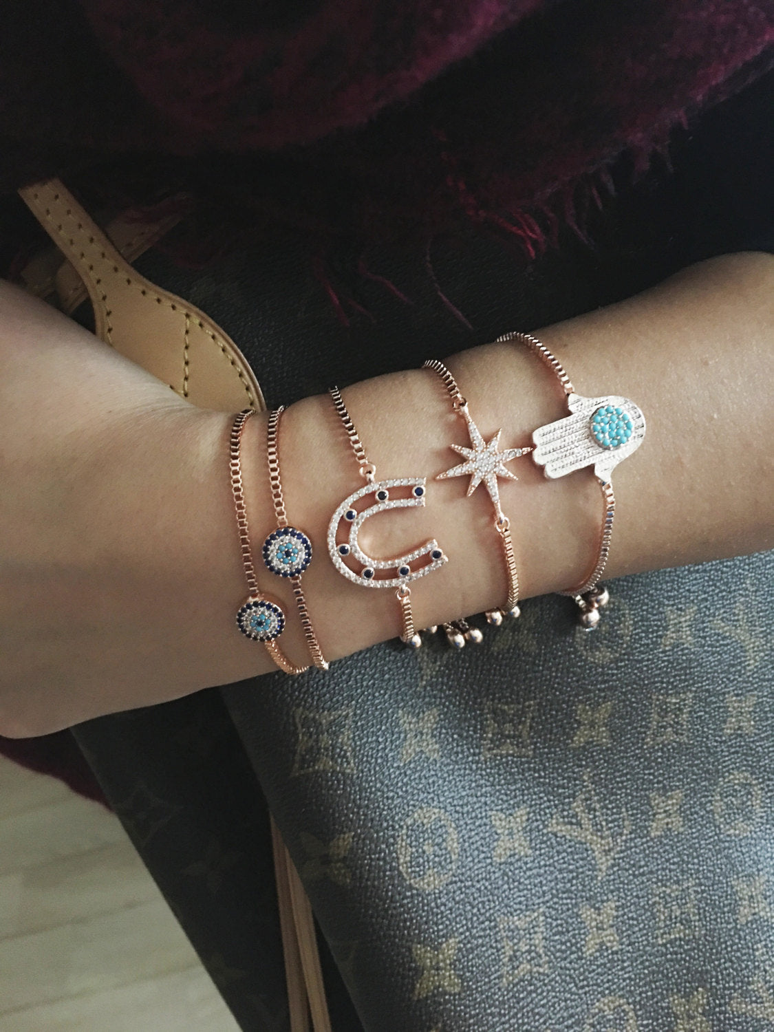 Rose gold adjustable evil eye bracelet, handmade with gold plating, featuring hamsa and horseshoe designs for protection and style.