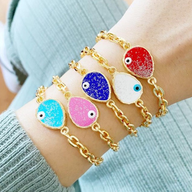 A beautiful Evil Eye Bracelet featuring a gold chain and a glittering teardrop evil eye charm, available in multiple colors.