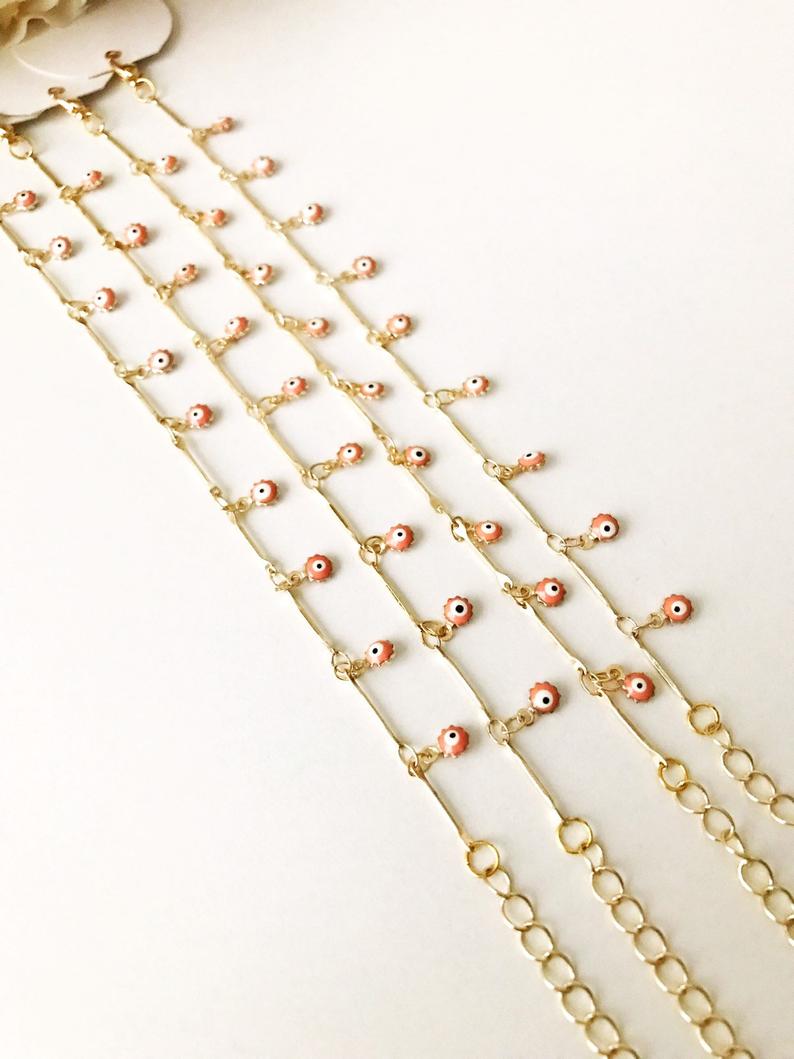 A delicate Evil Eye Bracelet featuring a gold chain and tiny blue evil eye bead, showcasing its minimalistic design.