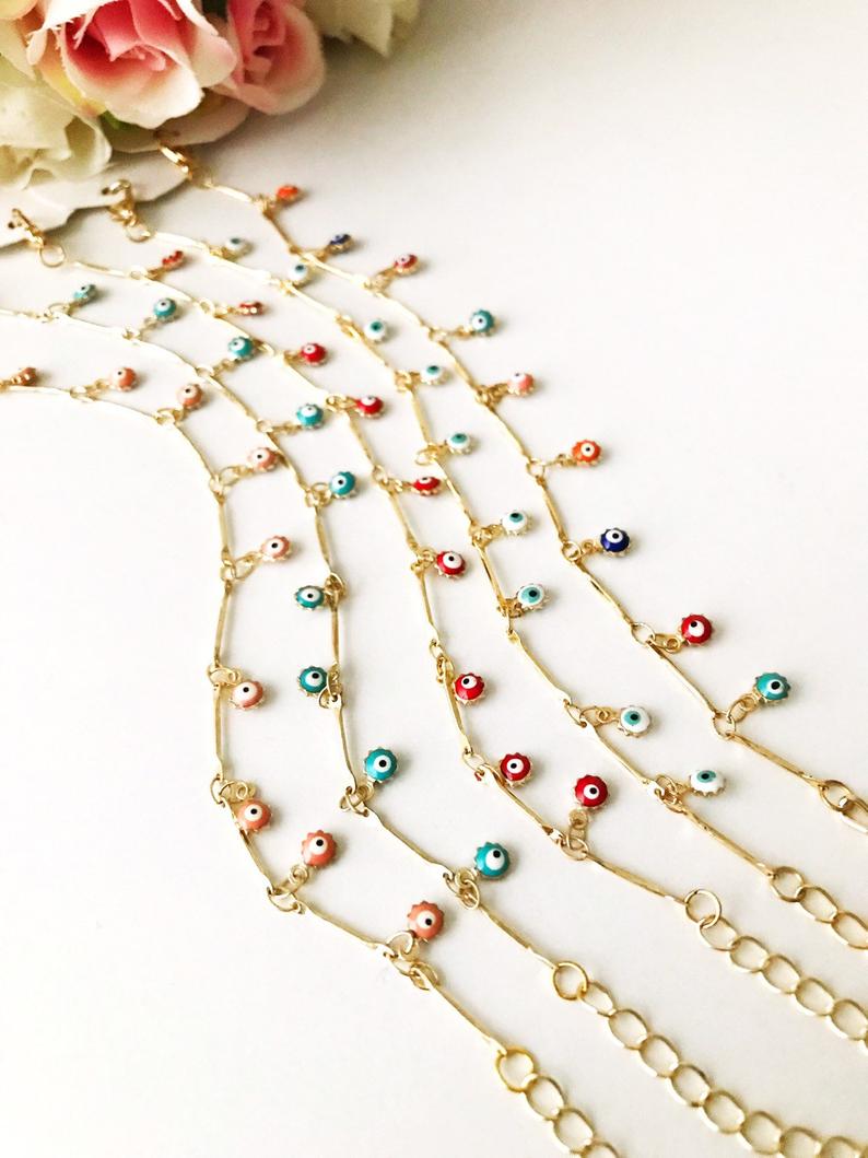 A delicate Evil Eye Bracelet featuring a gold chain and tiny blue evil eye bead, showcasing its minimalistic design.