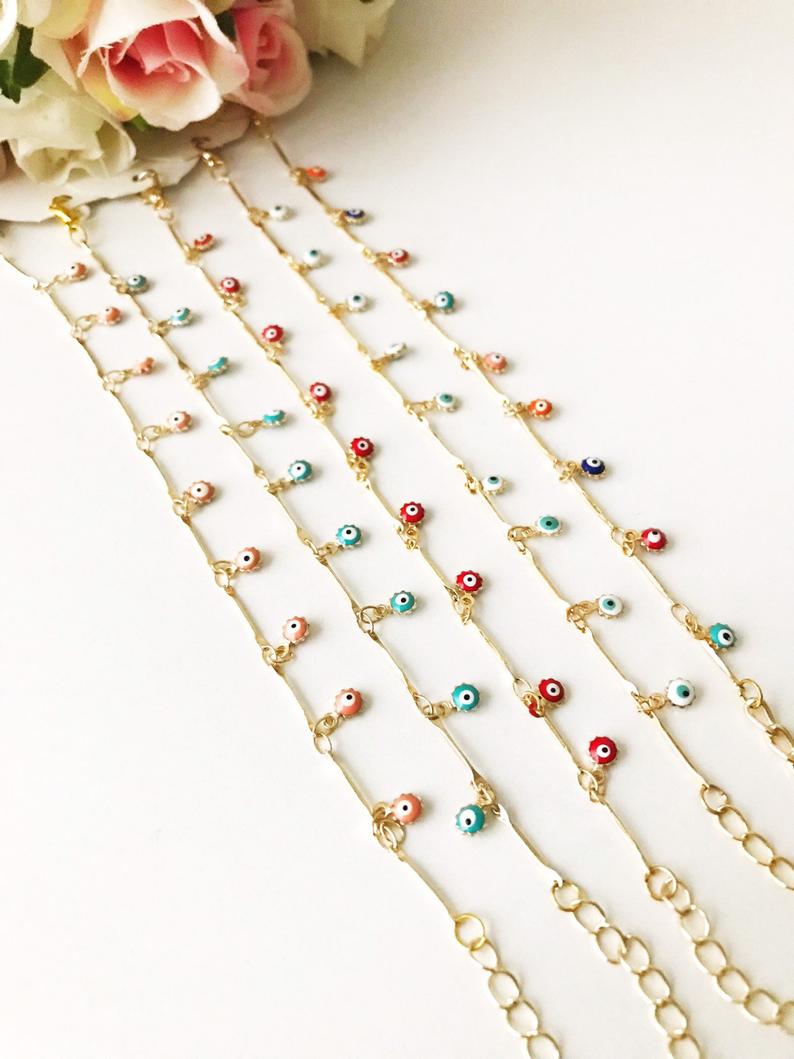 A delicate Evil Eye Bracelet featuring a gold chain and tiny blue evil eye bead, showcasing its minimalistic design.