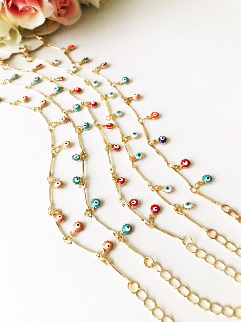 A delicate Evil Eye Bracelet featuring a gold chain and tiny blue evil eye bead, showcasing its minimalistic design.