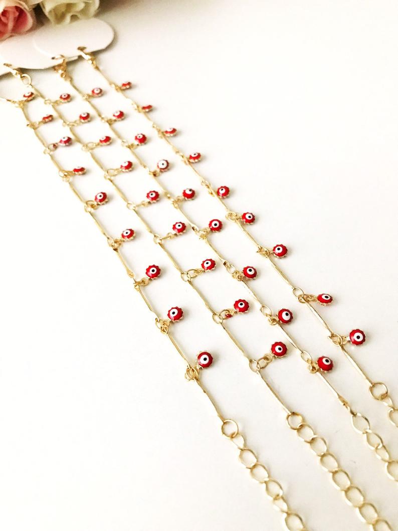 A delicate Evil Eye Bracelet featuring a gold chain and tiny blue evil eye bead, showcasing its minimalistic design.