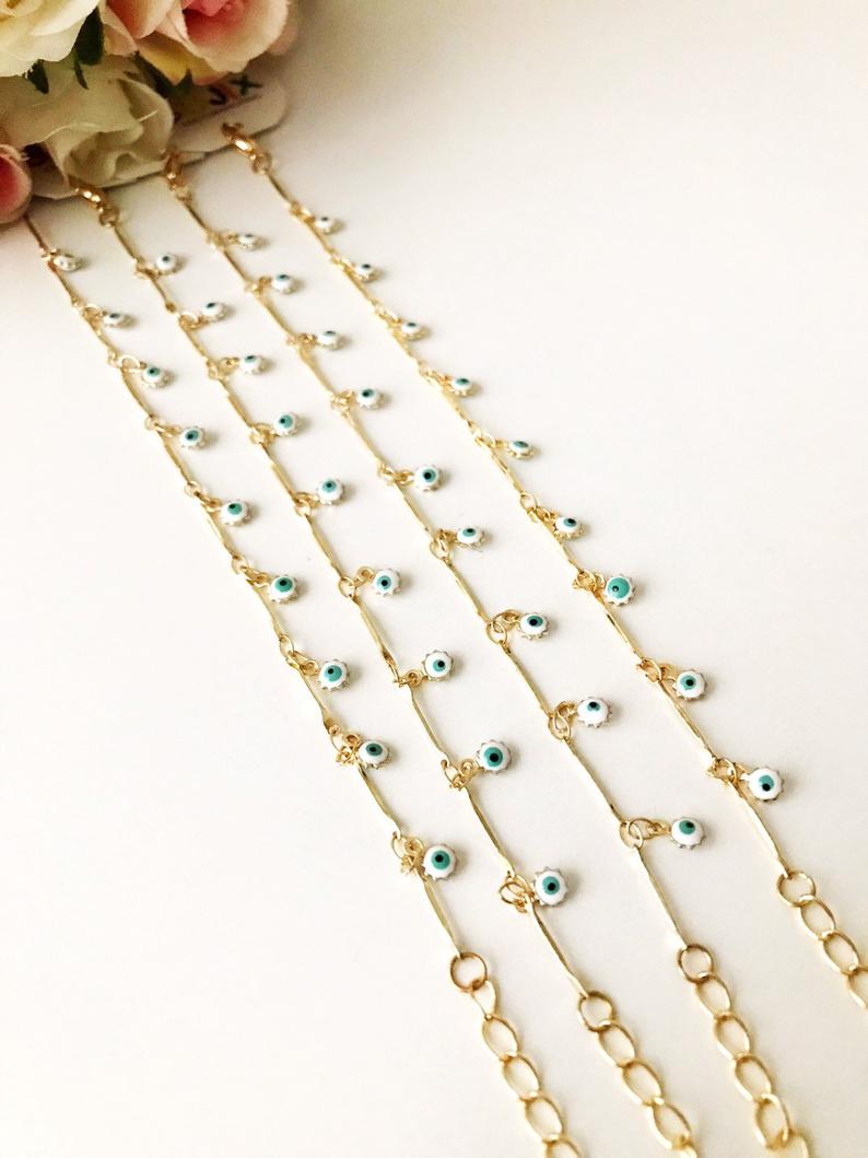 A delicate Evil Eye Bracelet featuring a gold chain and tiny blue evil eye bead, showcasing its minimalistic design.