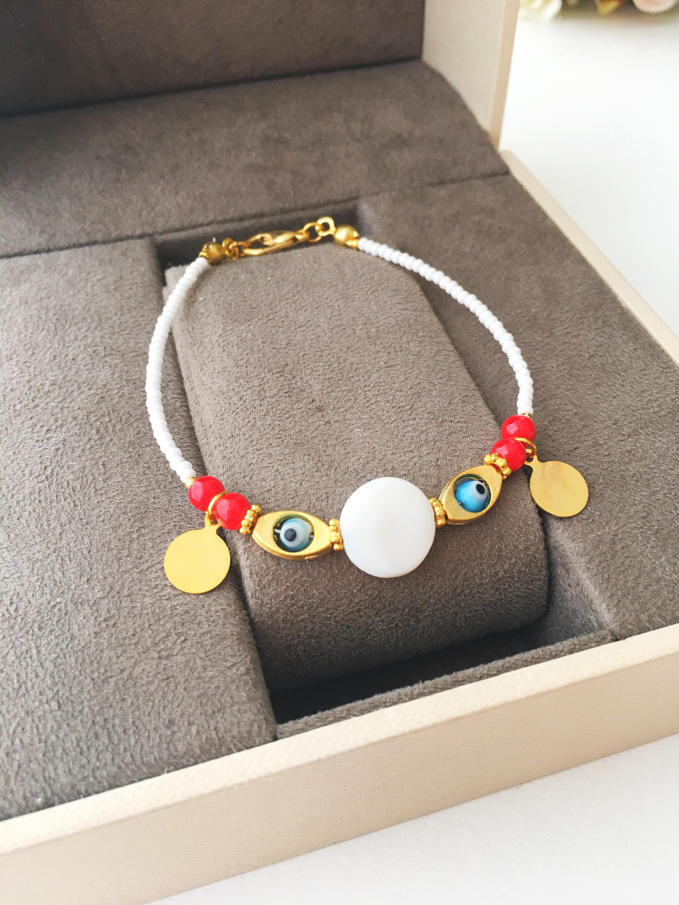 Handmade Evil Eye Bracelet featuring gold charm, white and black Miyuki seed beads, symbolizing luck and protection.