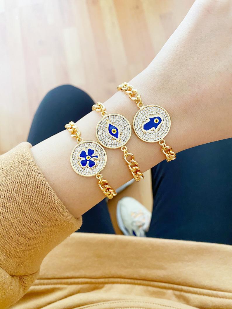 Elegant Evil Eye Bracelet featuring a gold link chain and clover charm, showcasing blue evil eye beads.