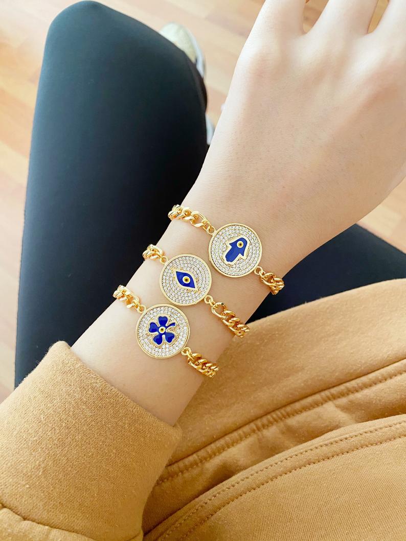 Elegant Evil Eye Bracelet featuring a gold link chain and clover charm, showcasing blue evil eye beads.