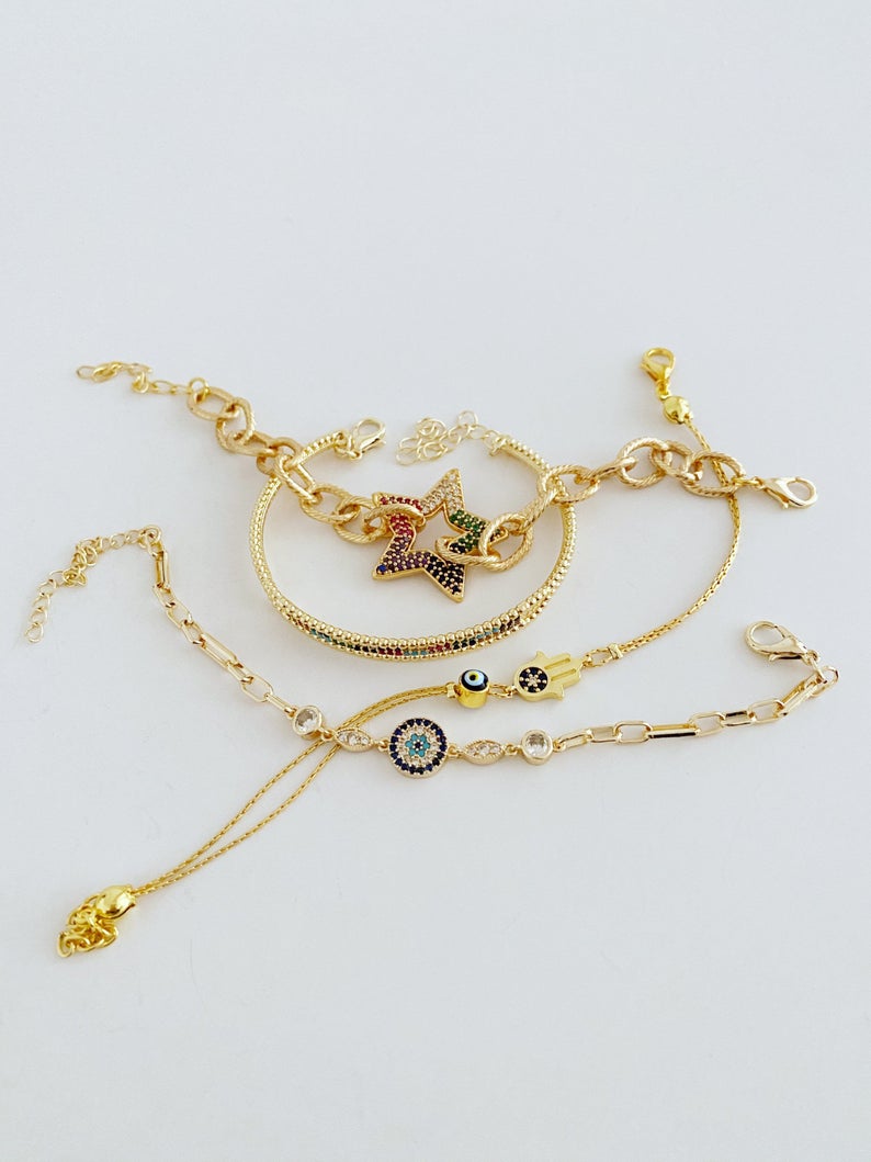 A beautiful Evil Eye Bracelet featuring a gold link chain, adjustable design, and handmade craftsmanship, showcasing its unique styles.