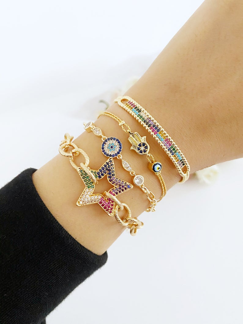 A beautiful Evil Eye Bracelet featuring a gold link chain, adjustable design, and handmade craftsmanship, showcasing its unique styles.