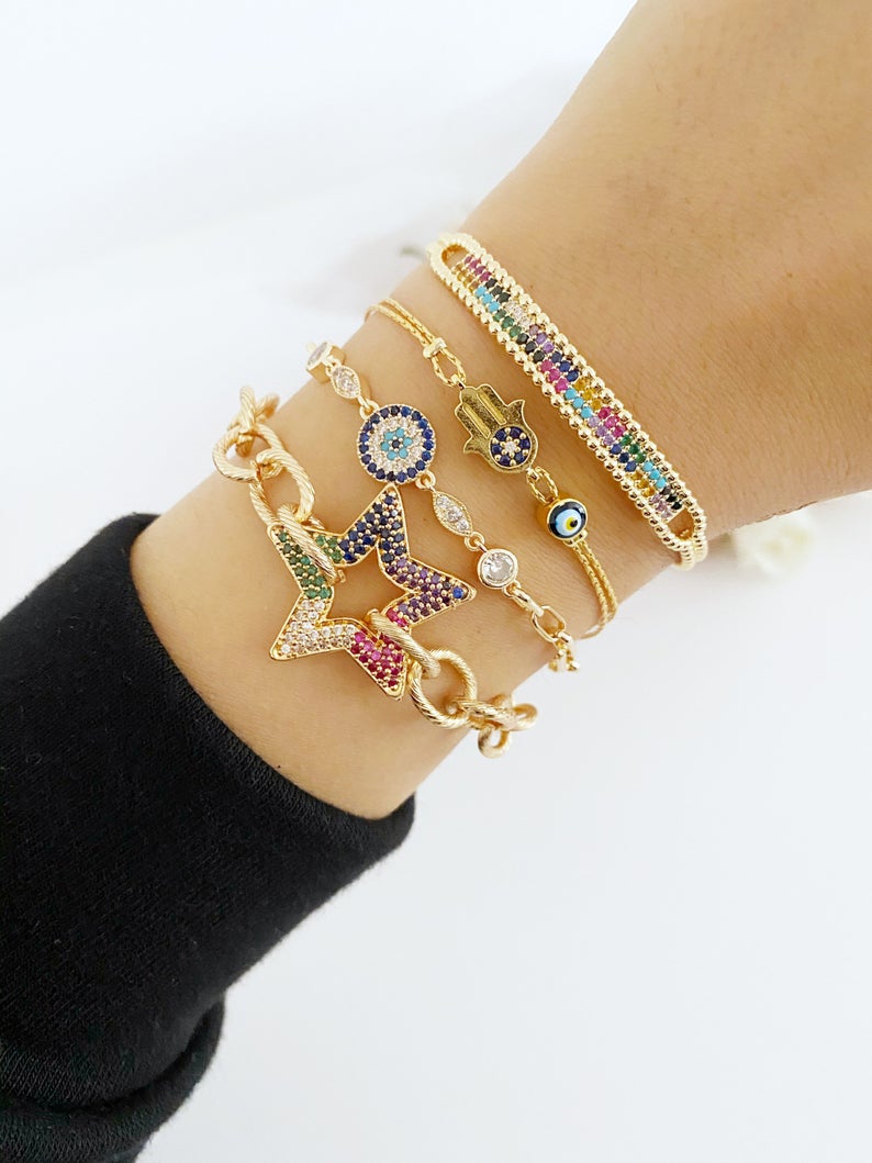 A beautiful Evil Eye Bracelet featuring a gold link chain, adjustable design, and handmade craftsmanship, showcasing its unique styles.