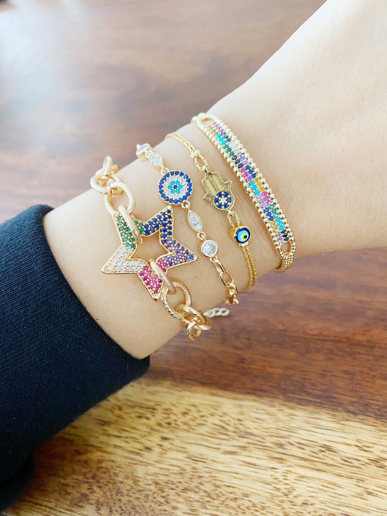 A beautiful Evil Eye Bracelet featuring a gold link chain, adjustable design, and handmade craftsmanship, showcasing its unique styles.