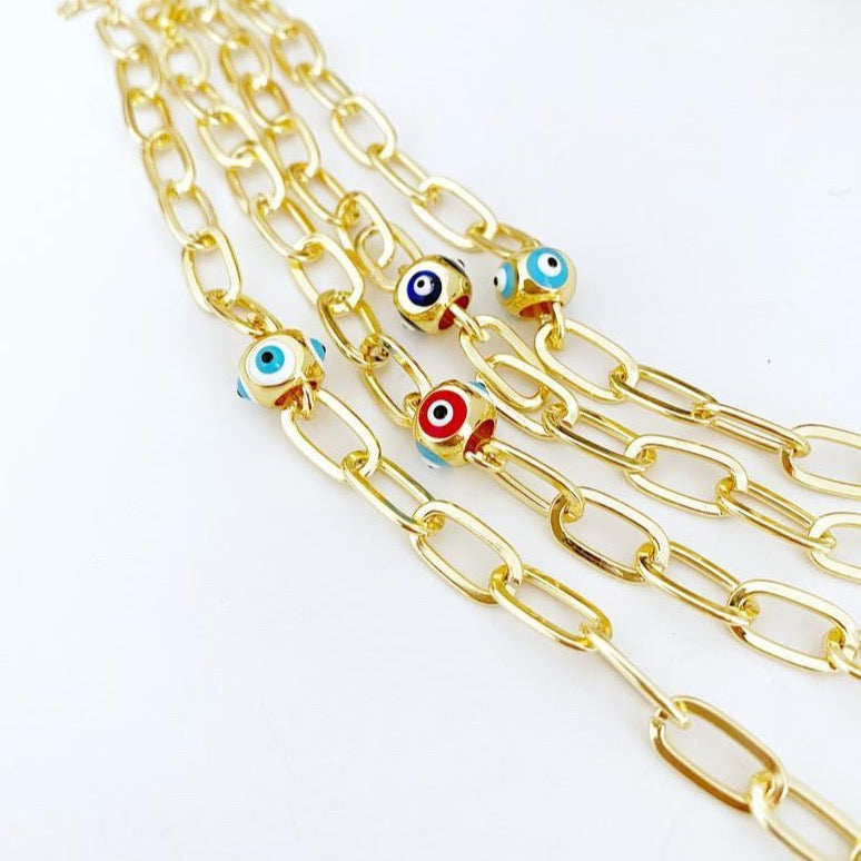 Evil Eye Bracelet Gold featuring an oval chain link design with a protective ball evil eye bead, available in multiple colors.
