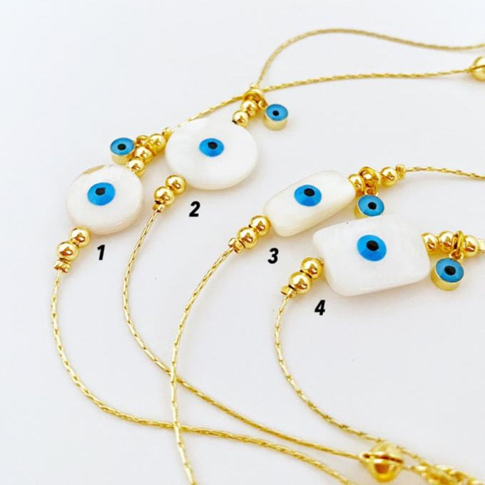 Elegant Evil Eye Bracelet featuring Mother of Pearl and gold chain, showcasing a blue Evil Eye symbol for protection.