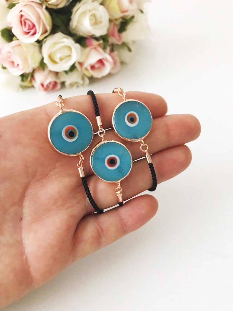 Handmade adjustable Evil Eye Bracelet featuring a 20mm baby blue Murano bead on a white string, symbolizing protection and style.