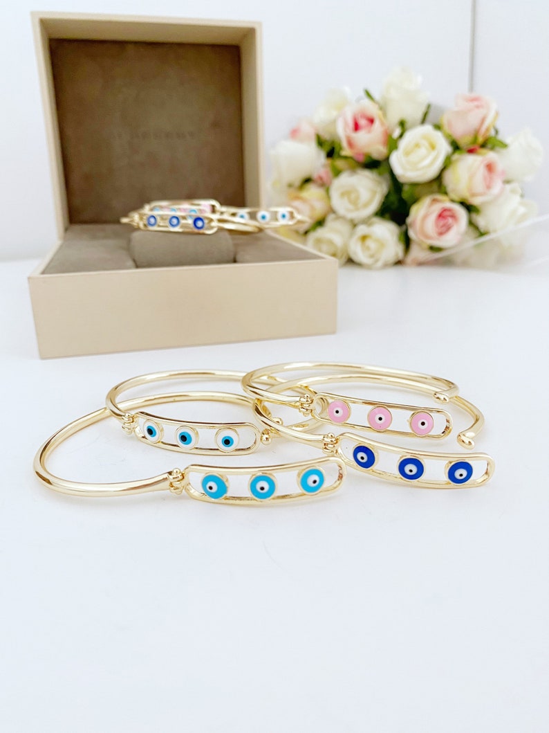 A beautiful pink and gold Evil Eye Bracelet featuring a movable oval charm, crafted from tarnish-resistant stainless steel, perfect for gifting.