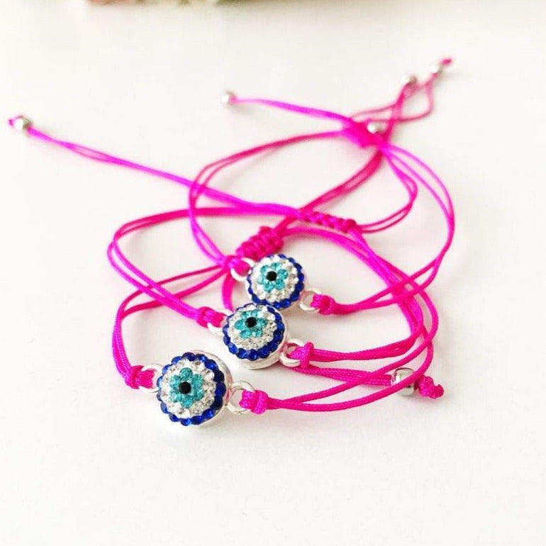 Handmade Evil Eye Bracelet featuring a pink string and a 10mm evil eye charm, adjustable for all wrist sizes.