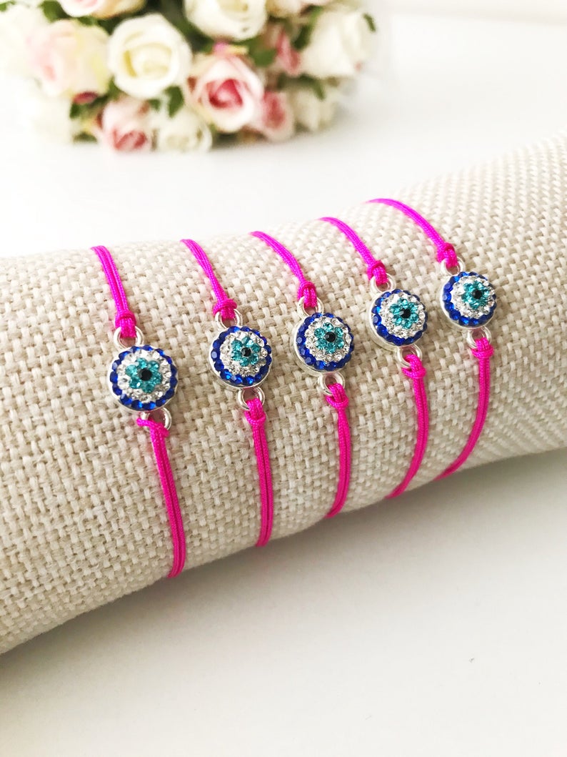 Handmade Evil Eye Bracelet featuring a pink string and a 10mm evil eye charm, adjustable for all wrist sizes.