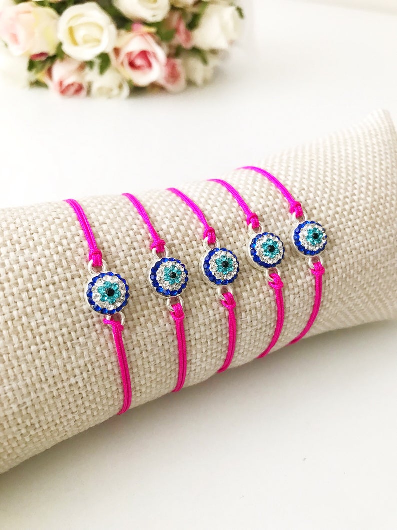 Handmade Evil Eye Bracelet featuring a pink string and a 10mm evil eye charm, adjustable for all wrist sizes.