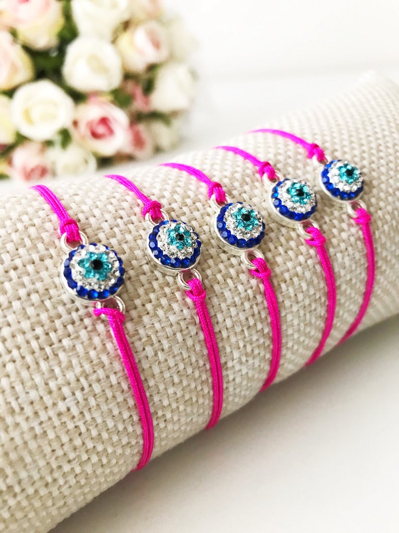 Handmade Evil Eye Bracelet featuring a pink string and a 10mm evil eye charm, adjustable for all wrist sizes.
