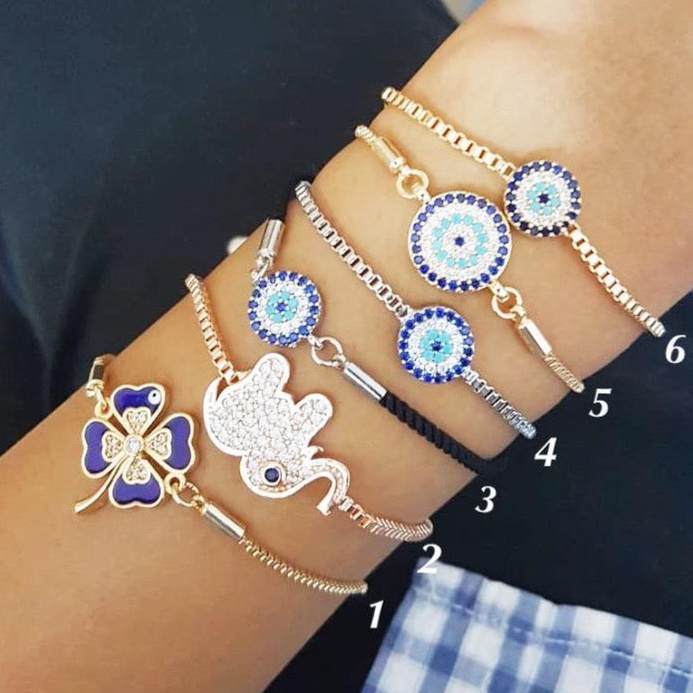 A beautifully crafted Evil Eye Bracelet Set featuring adjustable designs with clover and elephant charms in gold and silver.